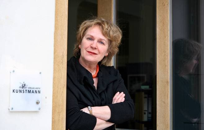 Verlegerin Antje Kunstmann (GER Verlag Antje Kunstmann GmbH) neben dem Firmenschild an der Tür des Verlages in München