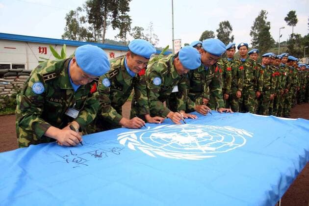 Soldaten der chinesischen UN-Friedenstruppe unterschreiben anlässlich des Internationalen Tag des Friedens in Bukavu auf einer Flagge der Vereinten Nationen - 