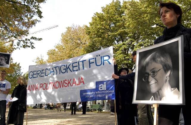Demonstrantin hält eine Bild der getöteten Journalistin Anna Politkowskaja (RUS) während einer Mahnwache anlässlich des Jahrestages ihrer Ermordung vor der russischen Botschaft in Berlin