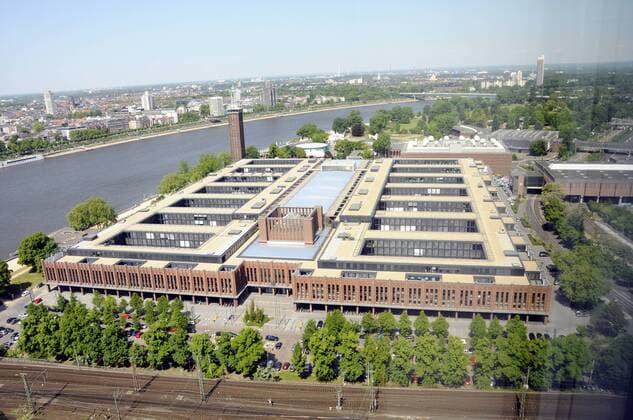 Köln Stadtansicht : Blick von oben auf die ehemaligen Rheinhallen die jetzt die Veraltung von RTL und die Versicherung HDI Gerling beheimaten - im Hintergrund der Rhein mit Rheinpark