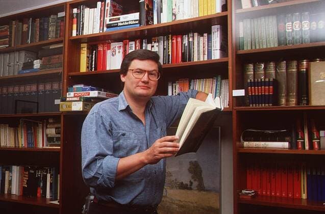 Sigmund Gottlieb 09 89 ru Mann Journalismus Moderation News Brille dunkelhaarig leger Homestory quer halb stehend Wohnzimmer Buch lächelnd