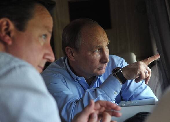 ITAR-TASS: SOCHI, RUSSIA. MAY 10, 2013. President of Russia Vladimir Putin, British Prime minister David Cameron (R-L) look through a helicopter window as they are flying over the Sochi Olympic Park along the Black Sea coast in the Imeretinskaya Valley.  Highlight RE11B522