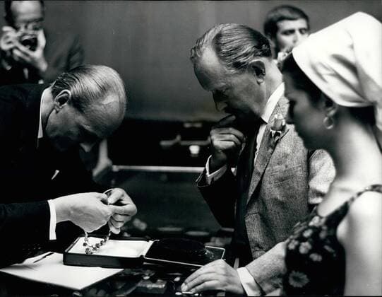 Jun. 16, 1966 - 16-6-66 Lady Pamela Hicks sells the famous Mountbatten emerald necklace for £42,000 â€âÄœ Lady Pamela Hicks, wife of interior decorator David Hicks, today sold the famous Mountbatten emerald necklace which was left to her by her mother, Lady Mountbatten. It went up for auction at Sotheby s in London, and was bought by Mr. M.A. Seymour for £42,000. The necklace, which was made in Paris, consists of nine magnificent emeralds arranged as drops from a diamond collar. The three centre emeralds alone weigh nearly 50 carats. Photo Shows: Mr. Llewellyn, the auctioneer, (left) has trouble with the elapse of the necklace watched by the buyer Mr. M.A. Seymour, and his 19-year old daughter Caroline, who was anxious to try it on. - ZUMAk09