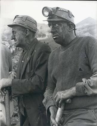 Oct. 22, 1966 - 71 dead and 58 entombed in Avalanche at Aberfan: At least 71 people, mostly children, are dead and between 58 and 60 still entombed at Aberfan, near Marthyr Tydfil, South Wales, after a rain-soaked coal tip avalanched on an infants school, a farm and a row of houses. Eighty five children are safe and 36 are in hospital. Photo shows two of the grim faced rescue workers at the scene of the disaster in Aberfan.  - ZUMAk09