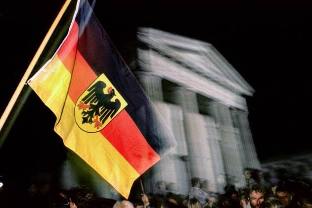 official celebration of reunification 1990, Berlin, Germany DEUTSCHLAND, 03.10.90.Berlin - Mitte.Feiern zur deutschen Wiedervereinigung:.Fahnenschwinger auf dem Pariser Platz am Brandenburger Tor. estost.com