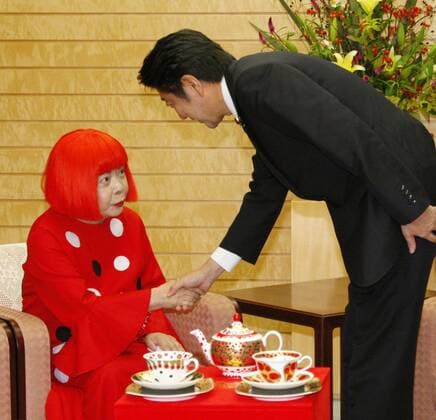 TOKYO, Japan - Renowned Japanese avant-garde artist Yayoi Kusama (L) shakes hands with Japanese Prime Minister Shinzo Abe at the premier s office in Tokyo on Sept. 18, 2013.  0918023