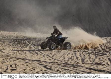 June 14, 2013 - Gaza City, Gaza Strip, Palestinian Territory - A Palestinian youth rides his motorcycle on sand dunes during the weekly sporting event in the town of Al-Zahra, in the southern Gaza City, on June 14, 2013. Palestinian youths use the dunes for riding their motorcycles, horses, cars and bicycles  - ZUMAews