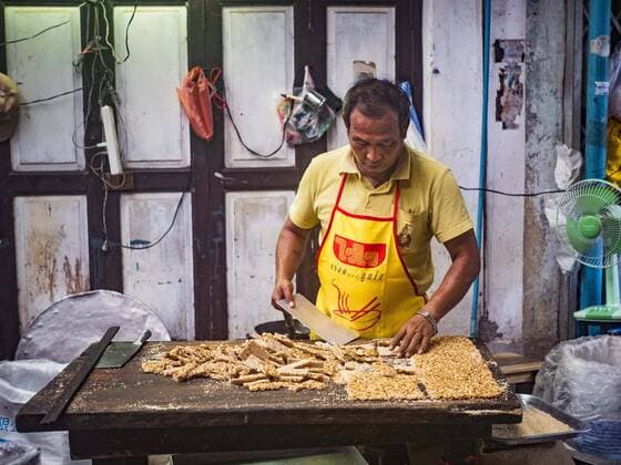 October 4, 2016 - Bangkok, Bangkok, Thailand - A vendor makes Chinese peanut and sesame seed snacks at the Vegetarian Festival at the Chit Sia Ma Chinese shrine in Bangkok. The Vegetarian Festival is celebrated throughout Thailand. It is the Thai version of the The Nine Emperor Gods Festival, a nine-day Taoist celebration beginning on the eve of 9th lunar month of the Chinese calendar. During a period of nine days, those who are participating in the festival dress all in white and abstain from eating meat, poultry, seafood, and dairy products. Vendors and proprietors of restaurants indicate that vegetarian food is for sale by putting a yellow flag out with Thai characters for meatless written on it in red. Bangkok Thailand - ZUMAk94_