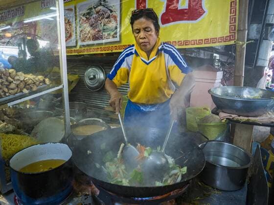 October 4, 2016 - Bangkok, Bangkok, Thailand - A vendor makes vegetarian fried noodles during the Vegetarian Festival at the Chit Sia Ma Chinese shrine in Bangkok. The Vegetarian Festival is celebrated throughout Thailand. It is the Thai version of the The Nine Emperor Gods Festival, a nine-day Taoist celebration beginning on the eve of 9th lunar month of the Chinese calendar. During a period of nine days, those who are participating in the festival dress all in white and abstain from eating meat, poultry, seafood, and dairy products. Vendors and proprietors of restaurants indicate that vegetarian food is for sale by putting a yellow flag out with Thai characters for meatless written on it in red. Bangkok Thailand - ZUMAk94_