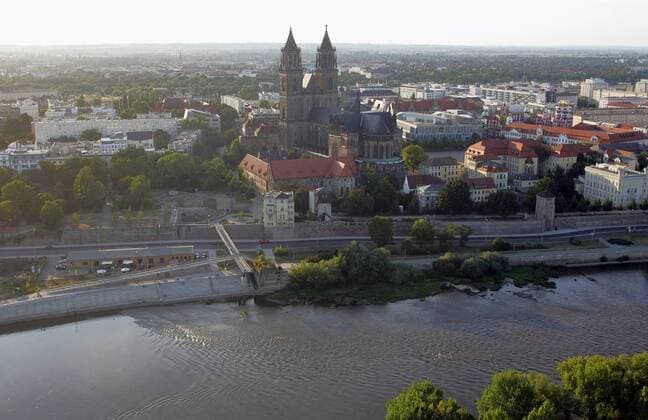 23.08.2009, Magdeburg, Sachsen-Anhalt, Deutschland - Luftbildaufnahme mit dem Magdeburger Dom an der Elbe. Der Dom des Erzbistums Magdeburg ist das aelteste gotische Bauwerk in Deutschland. Seit der Reformation ist der Dom evangelische Pfarr- und Bischofskirche. (QF, europäisch, Gebäude, Sakralgebäude, Sehenswürdigkeit, Türme, Überblick, Übersicht, Stadtübersicht, Stadtüberblick, Gewässer, Wohngebäude, Wohnhäuser) 00S090823D107.JPG MODEL RELEASE: NOT APPLICABLE, PROPERTY RELEASE: NO MR:Y