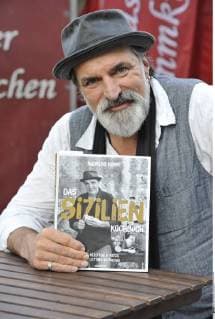 Andreas Hoppe Actor 10 17 THG Andreas Hoppe at 12 October 2017 w hrend the Frankfurt Book Fair trade Fair Literaturmesse Literature Frankfurt Main Germany German German Man Acting Film TV Television German Actor vertical half seated Cookbook Book Titles holding Sicily
