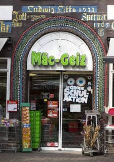 Half-timbered House in the old town of Höxter richly decorated entrance of cheap department store chain Mäc Geiz