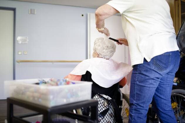A hairdresser is friezing an old woman in a wheelchair in a nursing home 27 04 2018 Berlin ONLY FOR EDITORIAL USE Berlin Germany Copyright: xIngaxKjer photothek.netx