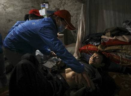 (190410) -- CHONGQING, April 10, 2019 (Xinhua) -- Medical workers conduct a physical check-up for a villager (R) who suffered polio at Youai Village of Taojia Town in Jiulongpo District, southwest China s Chongqing, Feb. 20, 2019. In almost eight years, more than 50 medical workers from a health center in Taojia Town have provided nearly 1,000 villagers with door-to-door medical services including physical check-up, health intervention and rehabilitation training. Because of limited access to villages, these medical workers have to shoulder medical equipment with baskets to treat villagers every month. Despite backward medical environment, they have been dedicated to offering free medical services just for the sake of villagers health. (Xinhua Lan Hongguang) CHINA-CHONGQING-RURAL DOCTORS (CN) 
