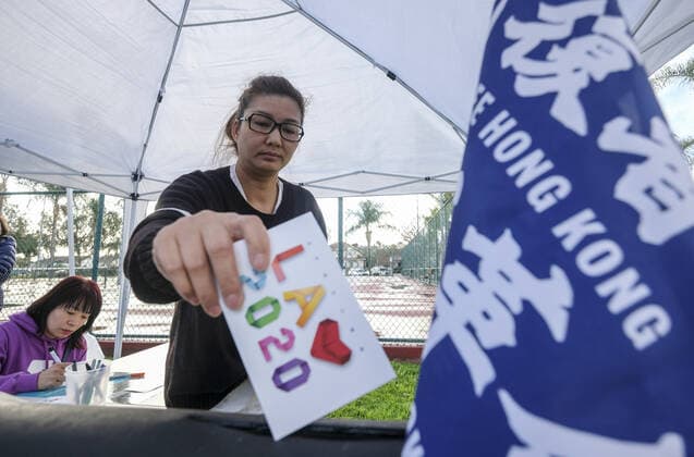 December 8, 2019, Los Angeles, California, U.S: A woman drop a holiday card into a box to support the pro democracy protesters in Hong Kong who are not able to spend the holiday with family, during the International Human Rights Day in Los Angeles on Sunday December 8, 2019. Los Angeles U.S. - ZUMAc68_ 20191208_zaf_c68_002 Copyright: xRingoxChiux