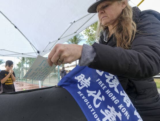 December 8, 2019, Los Angeles, California, U.S: A woman drop a holiday card into a box to support the pro democracy protesters in Hong Kong who are not able to spend the holiday with family, during the International Human Rights Day in Los Angeles on Sunday December 8, 2019. Los Angeles U.S. - ZUMAc68_ 20191208_zaf_c68_006 Copyright: xRingoxChiux