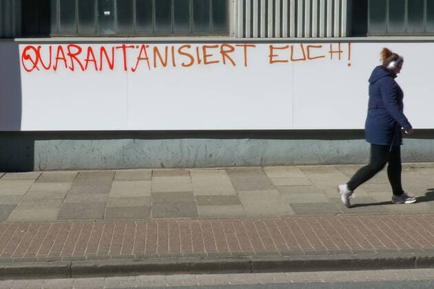 To contain the coronavirus, business closures have been ordered and curfews are being discussed, the photo shows a pedestrian in front of a graffiti, lettering on a building with the inscription Quarantine yourself, 22 03 2020, Bremen Germany , News, Feature, Coronavirus Bremen xobx
