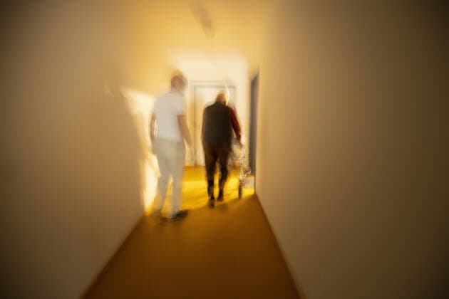 Topic Nurse and man with walker in a dark hallway Heidelberg Germany Copyright: xUtexGrabowsky photothek.netx