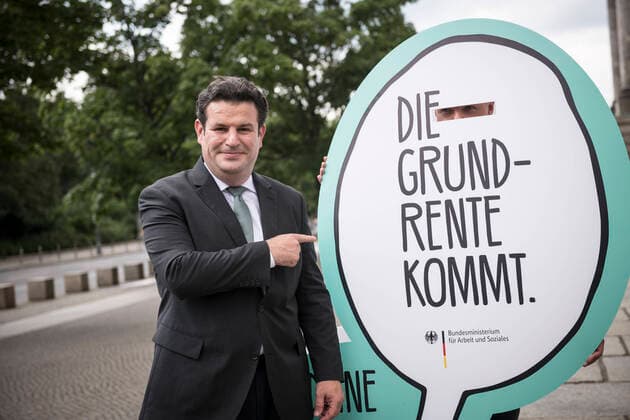Minister of Labour Hubertus Heil SPD stands on 27 2020 at the Reichstag building next to a display with the inscription Die Grundrente kommt Im Bundestag wurde heute die Grundrente beschlossen Foto bildgehege Grundrente