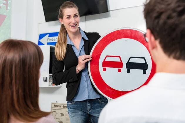 Driving instructor explaining meaning of street sign to class Copyright: xKzenonx Panthermedia27445071 ,model released, Symbolfoto
