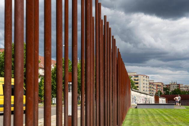 Tourists at the Berlin Wall Memorial on Bernauer Strasse in Berlin Prenzlauer Berg Rusty iron pipes mark the course of the border between East and West Berlin Photo Volker Hohlfeld Berlin Wall Memorial