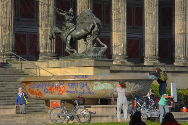 The granite bowl in front of the Altes Museum is damaged with graffiti graffiti
