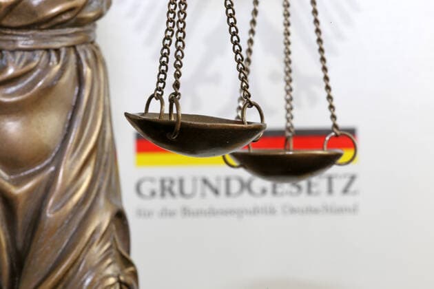 Close up of a Justitia in front of a german basic law book Copyright: xx
