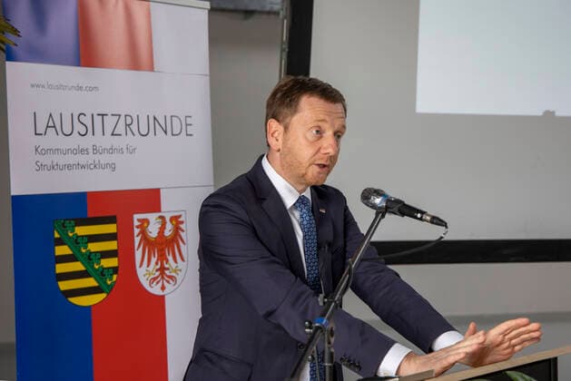 Sachsens Ministerpräsident Michael Kretschmer DEU Sachsen Schwarze Pumpe Â Sachsens Ministerpräsident Michael Kretschmer : Am Montag, 19. Oktober 2020, fand im Dock3 Lausitz am Industriepark Schwarze Pumpe die Konferenz der Großen Lausitzrunde statt. Neben verschiedenen Redebeiträgen von Vertretern der Landes- und Bundespolitik kam unter anderem auch Sachsens Ministerpräsident Michael Kretschmer zu Wort. Behandelt wurden die Themen Entwicklungsstrategie und Ansiedlungsoffensive Lausitz. Das neue Kompetenz- und Gründerzentrum Dock3 in Schwarze Pumpe. Es wude im Auftraggeber des Zweckverbandes Industriepark Schwarze Pumpe 2020 eröffnet, es liegt auf der Landesgrenze von Sachsen und Brandenburg. Das Kompetenzzentrum DockÂ³ soll Sta