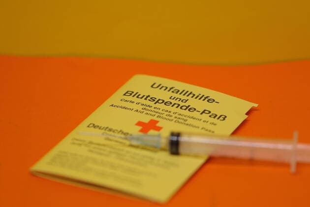 Frankenberg, Germany 13 December 2020 A passport for accident assistance and blood donation lies on an orange background, on the blood donation passport lies a syringe Hessen Copyright: xFotostandx xFreitagx