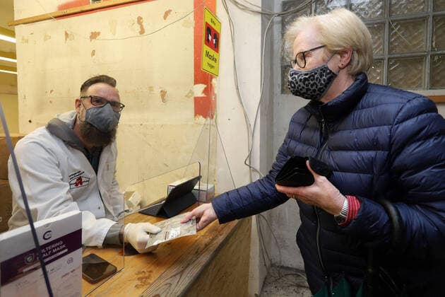 FFP2 masks distribution, a woman gets the free FFP2 masks in the pharmacy, the Glueckauf pharmacy in Niederschelden has an extra room next to the actual pharmacy where the masks are distributed to the specially targeted persons, the owner of the Glueckauf pharmacy Henning Schweisfurth li hands over the FFP2 masks