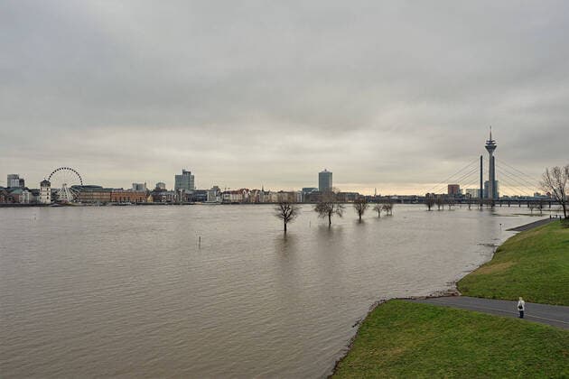 Duesseldorf, Germany 05 February 2021 View in direction of Duesseldorf from the Oberkasseler bridge at high water on the bank a person stands and looks at the Rhine North Rhine Westphalia Copyright: xFotostandx xGrosshantenx