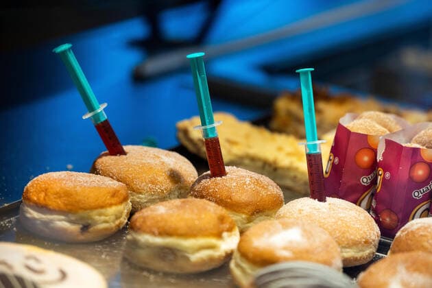 Pancakes with delicious Imfstoff syringes stuck in pancakes Berlin Krapfen in the display of a branch of the master baker Scherf The vaccine is strawberry jam and lets with the Krapfen despite Corona pandemic a little carnival feeling Ilmenau Thuringia GERMANY