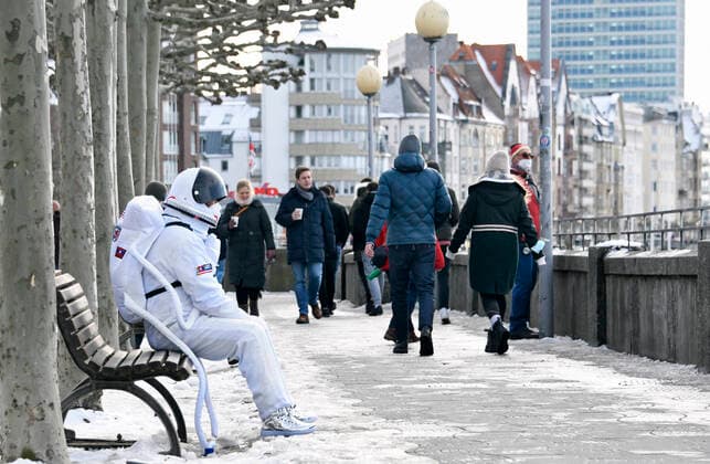 A lonely carnivalist dressed as an astronaut on carnival sunday on a bench in the old town of Düsseldorf