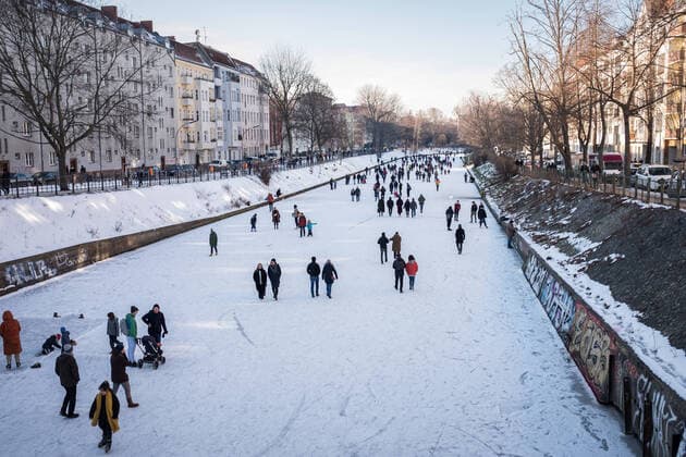 People walking on the frozen Landwehrkanal in Berlin Neukoelln Due to persistent frost the canal became a walking street Foto bildgehege Walking on the ice
