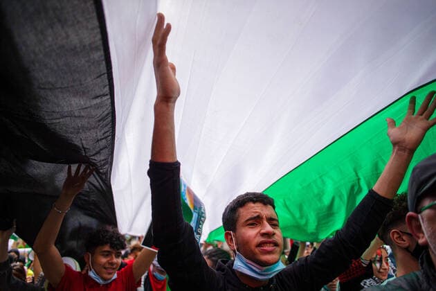 May 15, 2021, Madrid, Spain: protesters chant slogans under a giant Palestinian flag during a demonstration against the Israel attacks on the Palestinian people in Gaza. Madrid Spain - ZUMAs197 20210515_zaa_s197_105 Copyright: xLuisxSotox