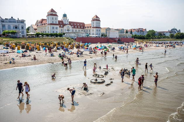 Vacation at the Baltic Sea In the Baltic Sea bath Binz on the island Rügen the tourists have arrived and enjoy with marvellous sunshine their well-deserved vacation View of the Kurhaus from the pier In the foreground children play in the Baltic Sea and build sand castles GER, island Rügen, Rügen, Baltic Sea bath Binz, Binz, Western Pomerania, Mecklenburg W