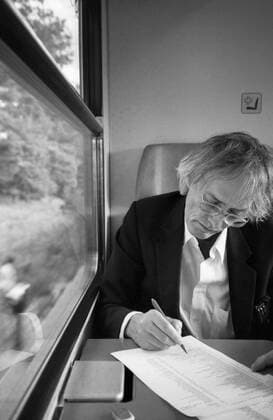 Timm Ulrichs on the train from Berlin to Magdeburg correcting flags for the catalogue Der detektorische Blick NGBK , 19 9 1997 On the way to a meeting about his design for the earth axis on the station forecourt in Magdeburg, which was inaugurated in 1999 Ulrichs used the train journey to correct printed flags for his catalogue at the NGBK Der dete