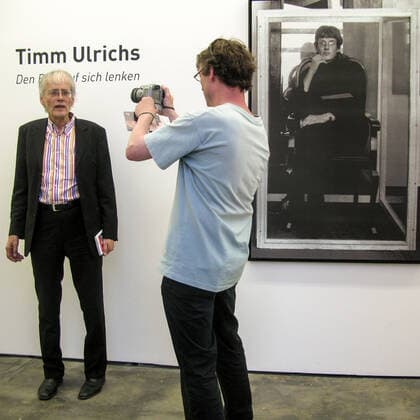 Timm Ulrichs in his exhibition Den Blitz auf sich lenken in der Galerie Wentrup, 11 6 2010 is portrayed by the Berlin photographer Jan Sobottka On the right a photo of the self-exhibition as the first living work of art at the Juryfreie Kunstausstellung, 1965 in Berlin, although he was not admitted there in the end, i.e. was juried out