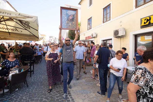 Blessed Virgin Mary celebration in CROATIA A man cary a painting of Virgin Mary as he leads an unofficial procession during a Feast of Assumption of the Blessed Virgin Mary celebration in Sinj, Croatia on August 15, 2021. No traditional procession is organized for the second year in a row due to the coronavirus disease (COVID-19) pandemic, but 27 Masses will be celebrated the Saint Joseph Catholic Church. MiroslavxLelas PIXSELL