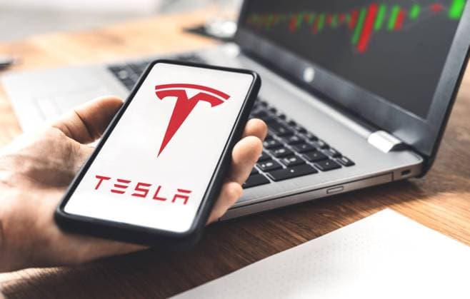 22 November 2021: Tesla car electric car logo on a smartphone, trading on the stock exchange with shares of Tesla stock by CEO Elon Musk, online trading with shares