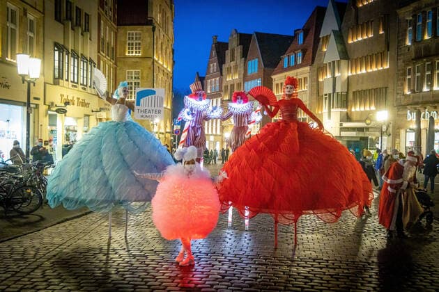 Advertising campaign of the Theater Münster in the city centre of Münster DEU, Germany, North Rhine Westphalia, Münster, 10 12 2021 Stilt walkers in colourful fantasy costumes Members of the Berlin Dulce Compania run advertising for the theatre programme of the 2021 2022 season of the Theater Münster