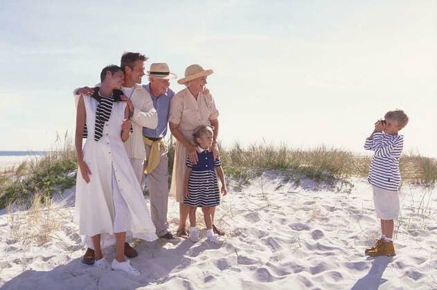 Beach scene,blonde boy takes a group photo of her family with her parents,grandparents and his little sister on the beach model released, Symbolfoto, 25.09.2021, Copyright: xnsp226bMicrox Panthermedia23615646