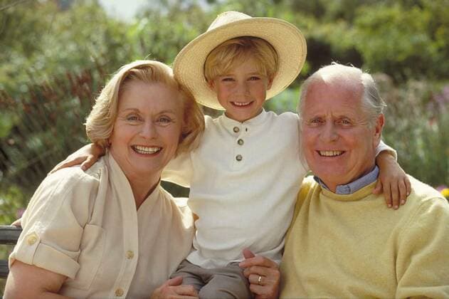 Outdoor,portrait,6-year-old blonde boy with straw hat between his grandparents sitting on a park bench model released, Symbolfoto, 25.09.2021, Copyright: xnsp226bMicrox Panthermedia23615918