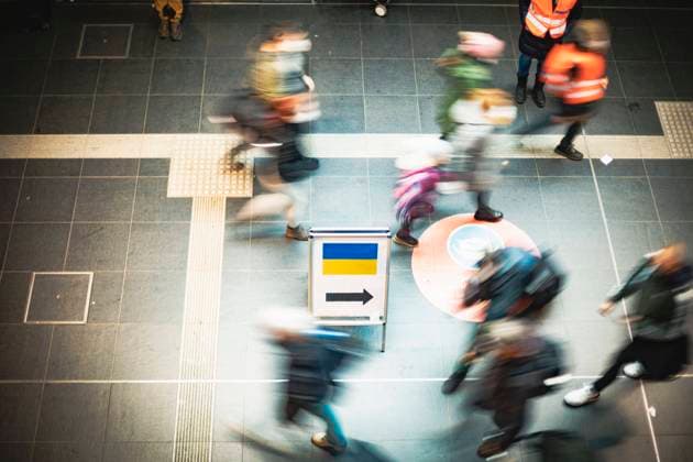 Arrival of refugees at Berlin Central Station, distribution of relief goods to refugees from Ukraine by volunteers at Berlin Central Station Several people walk past a sign for arriving Ukraine refugees Berlin Berlin Germany