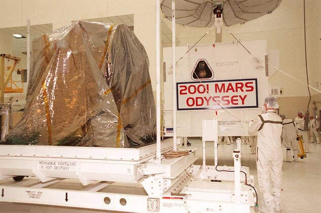 Workers in the Spacecraft Assembly and Encapsulation Facility 2 move the shipping crate away from the 2001 Mars Odyssey spacecraft, at left on the stand. Odyssey is still covered by a protective sheet. The spacecraft, which arrived from Denver, Colo., Jan. 4, will undergo final assembly and checkout in the SAEF-2. That includes installation of two of the three science instruments, integration of the three-panel solar array, and a spacecraft functional test. Launch aboard a Boeing Delta II launch vehicle from Pad A, Complex 17, CCAFS, is planned for April 7, 2001 the first day of a 21-day planetary window. The spacecraft will arrive at Mars on Oct. 20, 2001, for insertion into an initial elliptical capture orbit. Its final operational altitu Copyright: xpiemagsx piemagsspace-16267 !ACHTUNG AUFNAHMEDATUM GESCHÄTZT!
