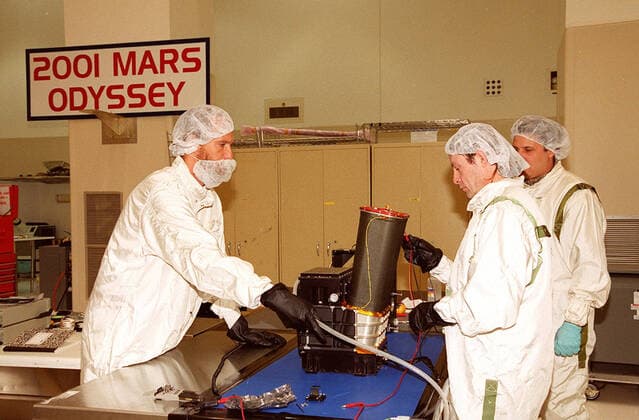 In the Spacecraft Assembly and Encapsulation Facility 2, workers test the Thermal Emission Imaging System (THEMIS) before attaching to the 2001 Mars Odyssey Orbiter. THEMIS will map the mineralogy and morphology of the Martian surface using a high-resolution camera and a thermal infrared imaging spectrometer. The orbiter will carry three science instruments: THEMIS, the Gamma Ray Spectrometer (GRS), and the Mars Radiation Environment Experiment (MARIE). The GRS will achieve global mapping of the elemental composition of the surface and determine the abundance of hydrogen in the shallow subsurface. The MARIE will characterize aspects of the near-space radiation environment with regards to the radiation-related risk to human explorers. The Ma Copyright: xpiemagsx piemagsspace-16475 !ACHTUNG AUFNAHMEDATUM GESCHÄTZT!
