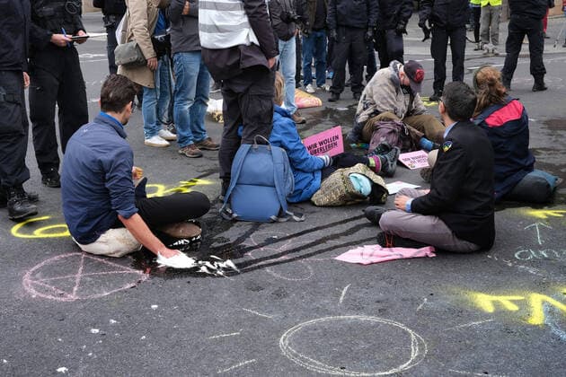19 09 2022, Berlin, DEU Activists from Extinction Rebellion protested against the further extraction and use of fossil fuels by sticking on the street at the intersection of Unter den Linden and Friedrichstrasse.