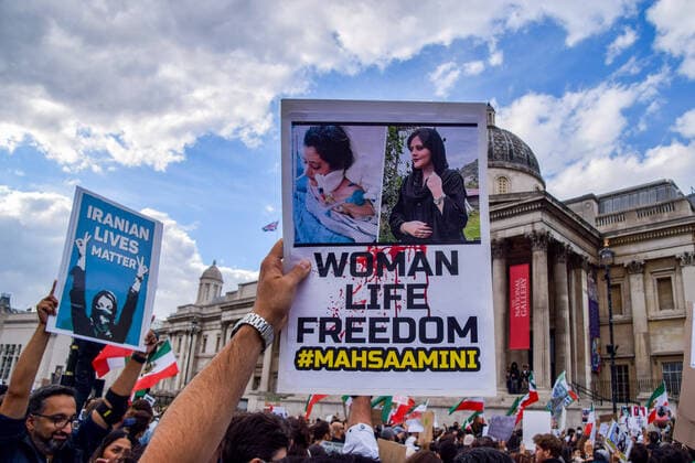 September 24, 2022, London, United Kingdom: A protester holds a placard with portraits of Mahsa Amini which states Woman, life, freedom during the demonstration. Thousands of Iranians and other protesters gathered in Trafalgar Square in response to the death of Mahsa Amini, who died in police custody in Iran after being detained for allegedly not wearing a head scarf (hijab) properly in public. London United Kingdom - ZUMAs197 20220924_zaa_s197_222 Copyright: xVukxValcicx