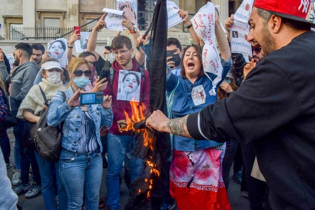 September 24, 2022, London, United Kingdom: Protesters burn a hijab during the demonstration. Thousands of Iranians and other protesters gathered in Trafalgar Square in response to the death of Mahsa Amini, who died in police custody in Iran after being detained for allegedly not wearing a head scarf (hijab) properly in public. London United Kingdom - ZUMAs197 20220924_zaa_s197_225 Copyright: xVukxValcicx