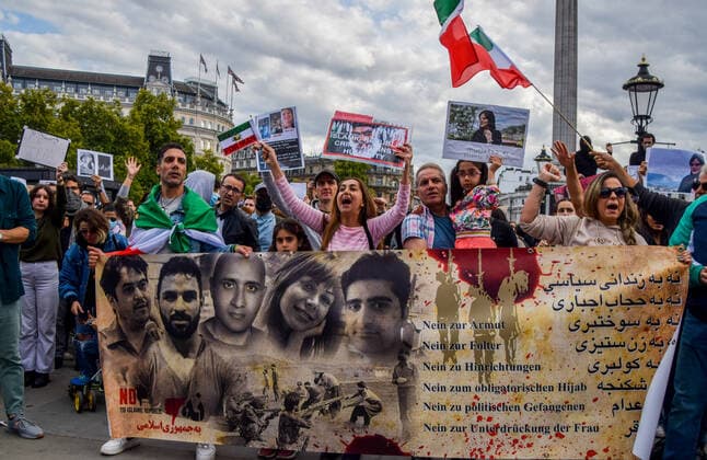 September 24, 2022, London, United Kingdom: Protesters hold anti-Iran regime placards and a banner during the demonstration. Thousands of Iranians and other protesters gathered in Trafalgar Square in response to the death of Mahsa Amini, who died in police custody in Iran after being detained for allegedly not wearing a head scarf (hijab) properly in public. London United Kingdom - ZUMAs197 20220924_zaa_s197_226 Copyright: xVukxValcicx